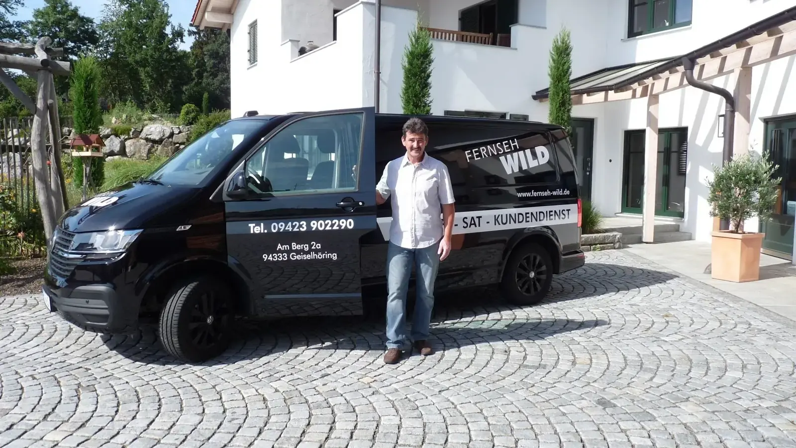 Servicefahrzeug von Fernseh Wild mit Techniker vor einem Wohnhaus in Geiselhöring