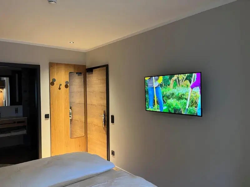 Wandmontierter Fernseher in einem Hotelzimmer – Referenzprojekt von Fernseh Wild