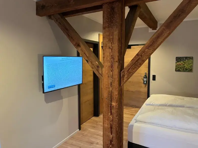 Fernseher im Hotelzimmer mit Holzbalken – TV-Installation für Hotels
