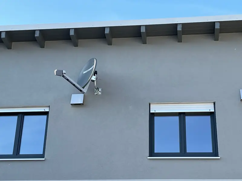 Satellitenschüssel an einer Hausfassade montiert